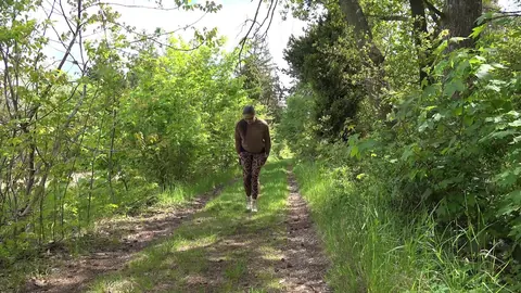 European in Glasses Lowers Yoga Pants to Pee on the Forest Path – photo 1 of 15