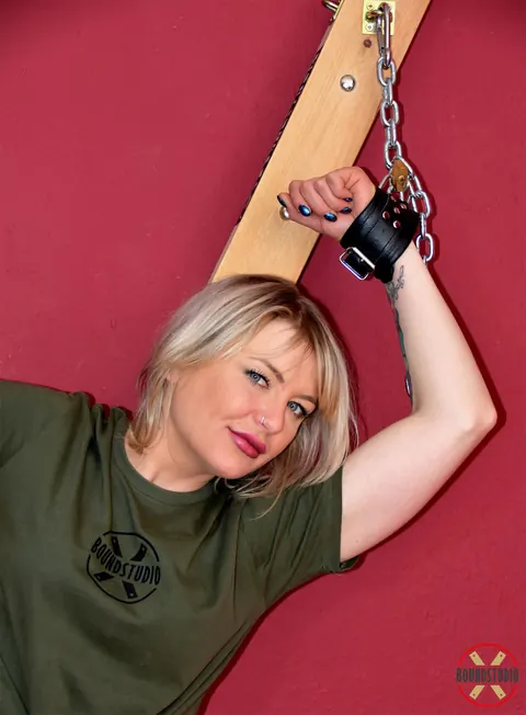 Tattooed Blonde Bound to a Cross in Shorts and Socks – photo 1 of 16