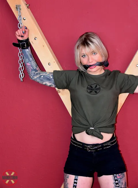 Tattooed Blonde Bound to a Cross in Shorts and Socks – photo 4 of 16