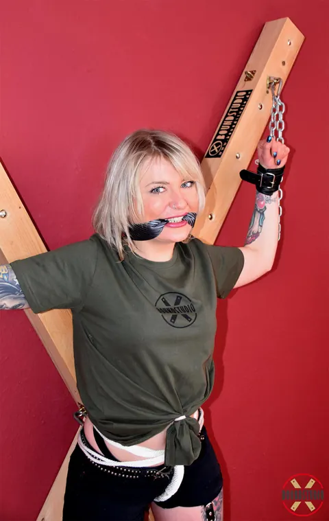 Tattooed Blonde Bound to a Cross in Shorts and Socks – photo 10 of 16
