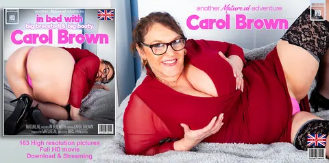 Carol Brown: Curvy British MILF Poses on the Bed in Stockings and Glasses – photo 11 of 11