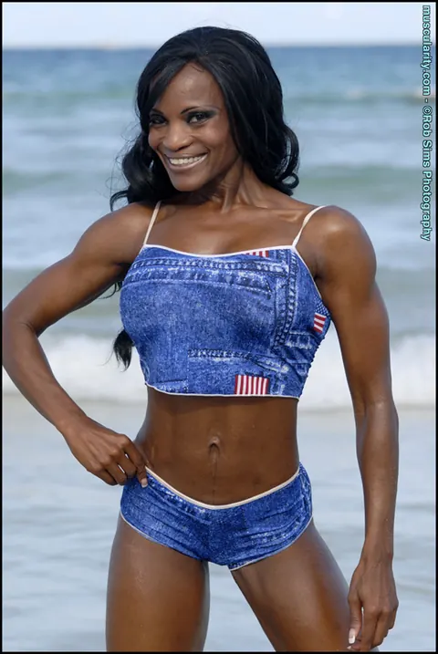 Debra Dunn: Busty Ebony MILF Flexes Her Muscles in a Bikini and Jeans on the Beach – photo 9 of 15
