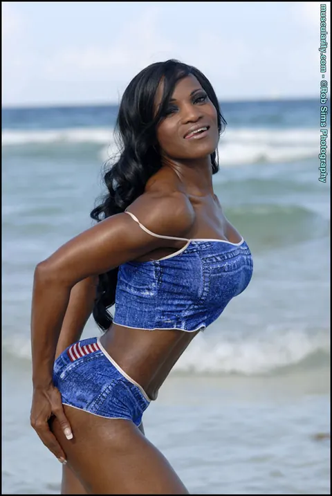 Debra Dunn: Busty Ebony MILF Flexes Her Muscles in a Bikini and Jeans on the Beach – photo 5 of 15
