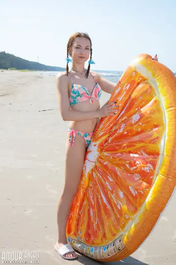 Slim Woman in Braided Pigtails Doffs Her Bikini on the Beach