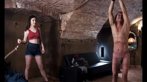 Brunette MILF in Shorts Canes Tied-Up Slave and Kisses Him – photo 1 of 12