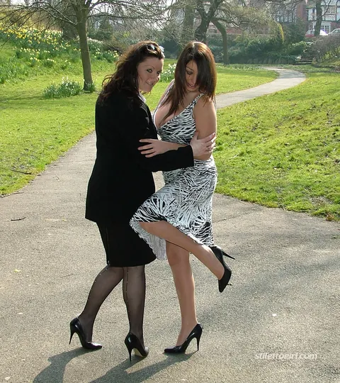 Two Women in Skirts, Stockings and Heels Kiss Outdoors – photo 2 of 16