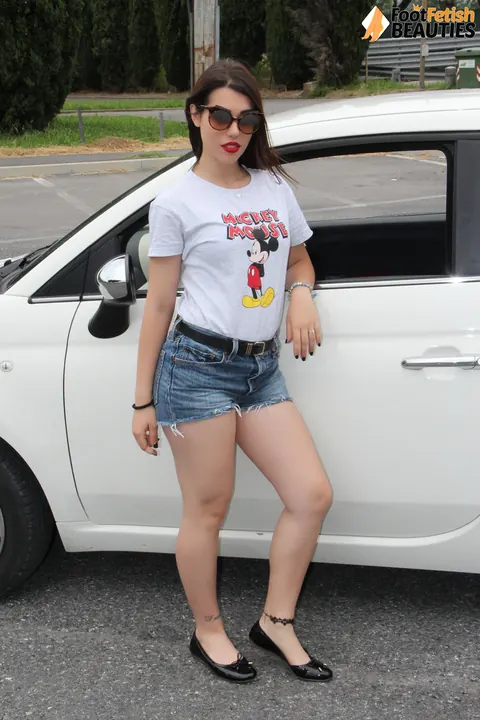 Outdoors, a Brunette in Shorts and Glasses Shows Her Feet – photo 1 of 10
