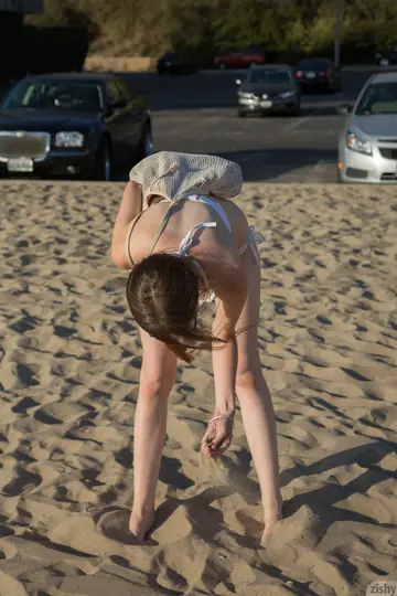 Petite Redhead in a Bikini and Glasses Spreads on the Beach