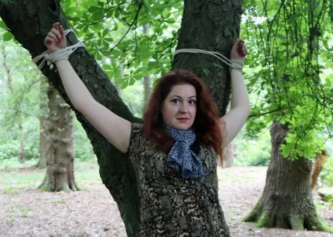 Redhead Bound to a Tree in a Forest Wearing a Skirt – photo 8 of 16
