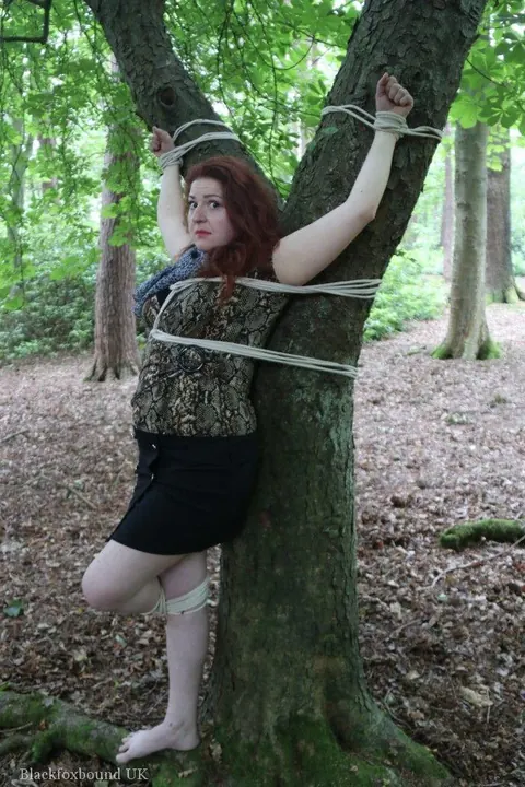 Redhead Bound to a Tree in a Forest Wearing a Skirt – photo 6 of 16