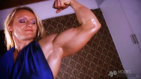 Brigita Brezovac: Blonde MILF Flexes Her Muscles in a Dress at the Gym – photo 9 of 21