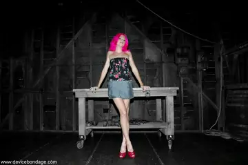 Skinny Redhead in a Skirt and Heels Poses in Bondage Dungeon