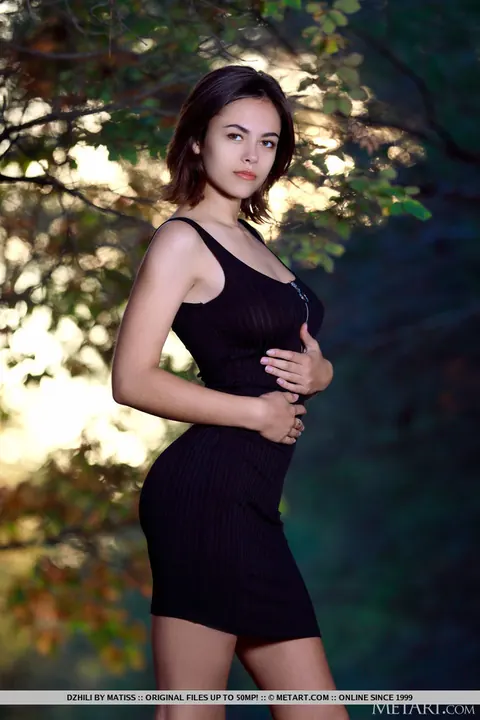 Woman in a Black Dress and High Heels Strips in the Forest – photo 1 of 18