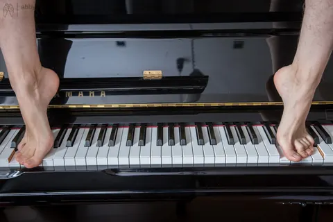 Slim Short-Haired Woman in Glasses Spreads on a Piano Bench – photo 16 of 16