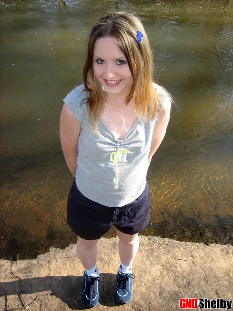 Amateur Woman in Shorts Flashes Her Tits by a Stream – photo 10 of 12