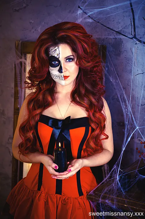 Curly Redhead in Glasses Poses in a Red Halloween Dress Outdoors – photo 1 of 15