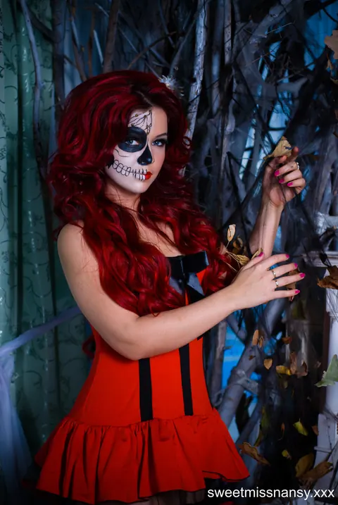 Curly Redhead in Glasses Poses in a Red Halloween Dress Outdoors – photo 11 of 15