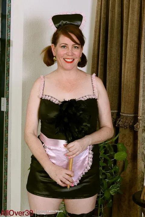 Caitlin Moore: Busty Redhead MILF Strips Off Her Maid Uniform in Stockings and Heels – photo 1 of 15