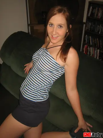 Redhead Strips Out of Her Skirt and Fingers Her Pussy on the Sofa
