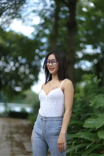 Asian Woman in Glasses and Jeans Poses and Undresses
