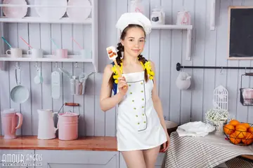 Slim Woman in Pigtails Strips and Spreads on the Kitchen Table