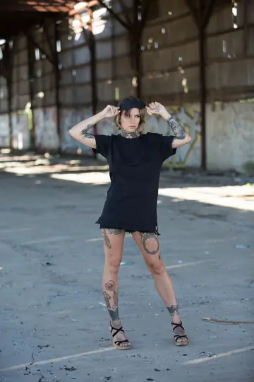 Short-Haired Tattooed Woman Poses Nude in Public Wearing Glasses