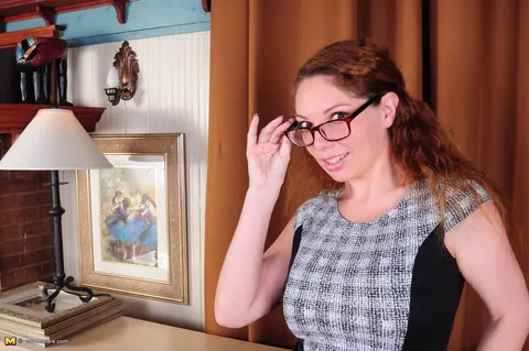 Kiki Daire: Redhead MILF in Lingerie and Glasses Undresses After Reading – photo 4 of 16