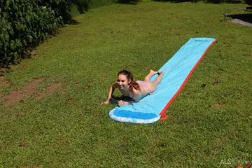 Brunette in a Bikini and Panties Spreads on a Garden Slide