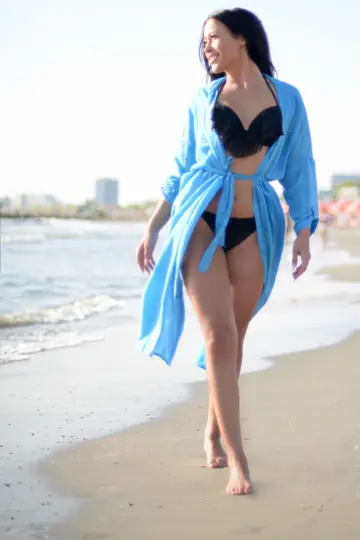 Woman Drops Her Robe to Pose in a Black Bikini on the Beach