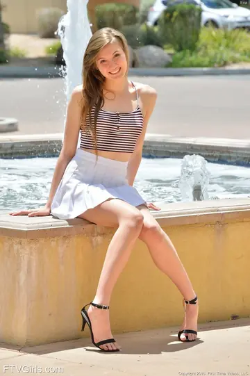 Skinny Brunette in a Skirt and Heels Spreads Outdoors
