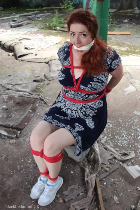 Curvy Redhead Bound and Gagged to a Post in a Warehouse – photo 14 of 16