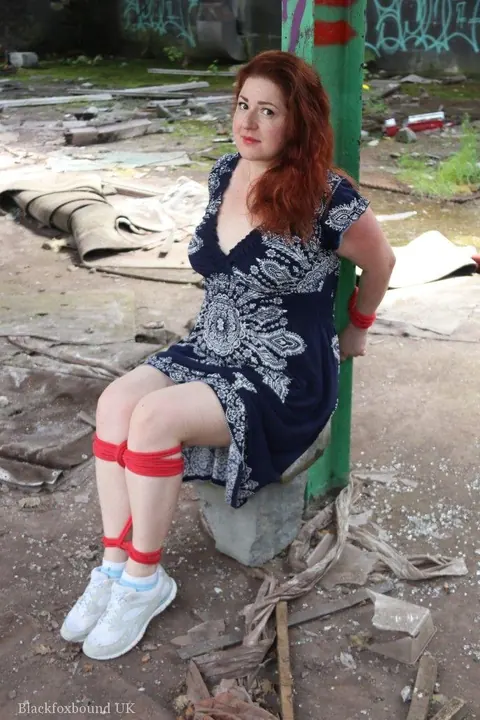 Curvy Redhead Bound and Gagged to a Post in a Warehouse – photo 4 of 16