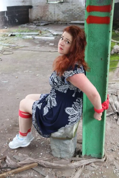 Curvy Redhead Bound and Gagged to a Post in a Warehouse – photo 5 of 16