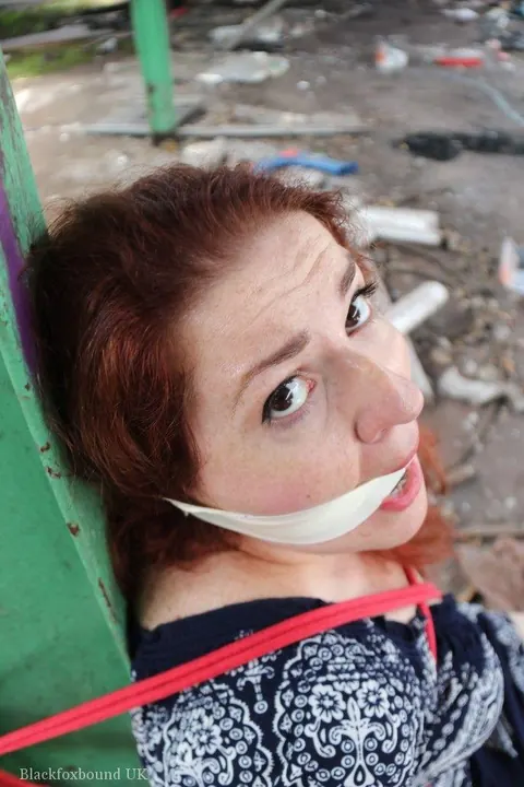 Curvy Redhead Bound and Gagged to a Post in a Warehouse – photo 2 of 16