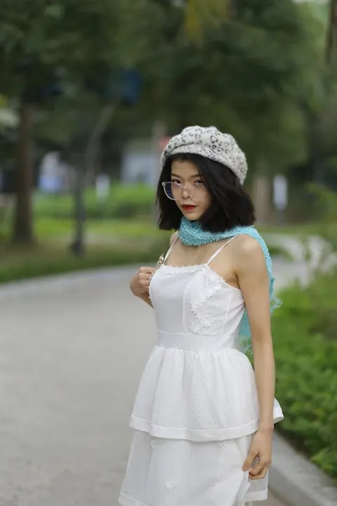 Asian Brunette Poses in a White Dress and Hat Outdoors – photo 7 of 21