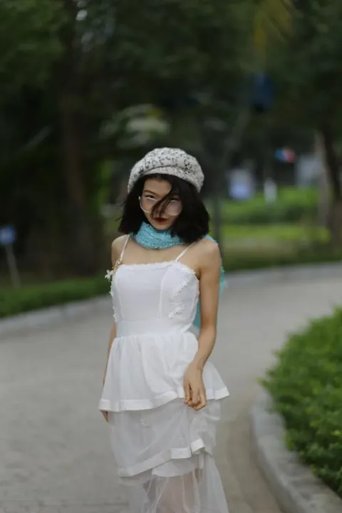 Asian Brunette Poses in a White Dress and Hat Outdoors – photo 13 of 21