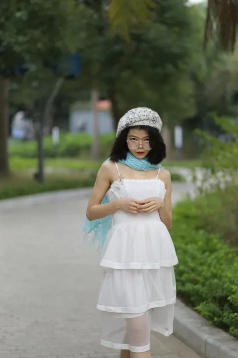 Asian Brunette Poses in a White Dress and Hat Outdoors – photo 2 of 21