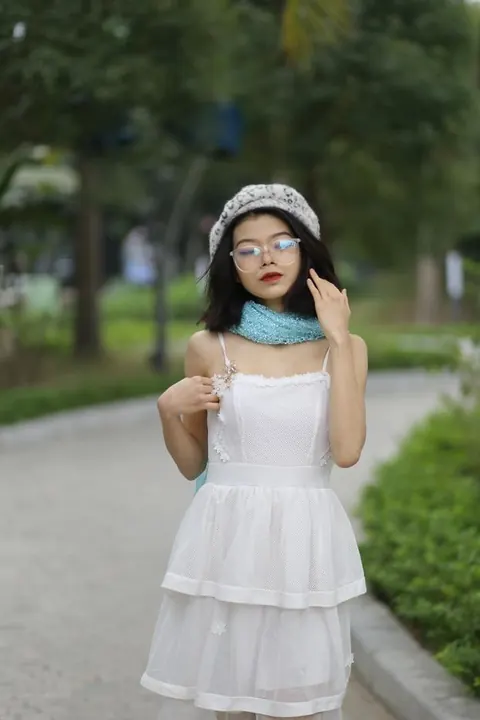 Asian Brunette Poses in a White Dress and Hat Outdoors – photo 9 of 21
