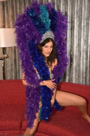 Skinny Latina Perches on a Red Sofa in a Showgirl Costume