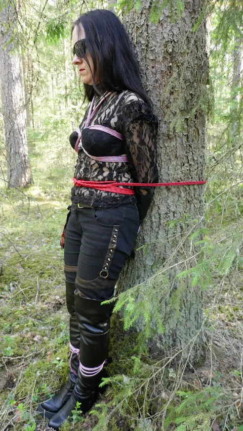 Brunette Bound to a Tree in Leather and Glasses Outdoors – photo 9 of 16