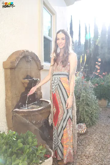 Tali Dova – Brunette in a Skirt Shows Her Legs in the Garden