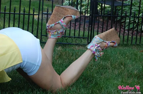 Kelly Anderson: Brunette MILF in Shorts and High Heels Shows Her Feet on Lush Grass – photo 6 of 15
