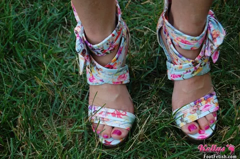 Kelly Anderson: Brunette MILF in Shorts and High Heels Shows Her Feet on Lush Grass – photo 2 of 15