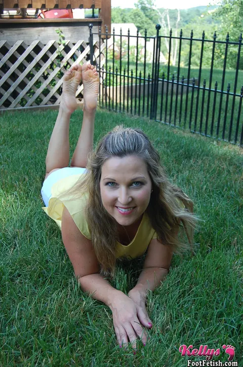 Kelly Anderson: Brunette MILF in Shorts and High Heels Shows Her Feet on Lush Grass – photo 15 of 15