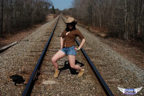 Emily Love: Amateur Brunette in Shorts and Boots Spreads on Railway Tracks – photo 1 of 12