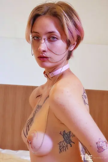 Short-Haired Woman with Tattoos and Piercings Uses a Toy