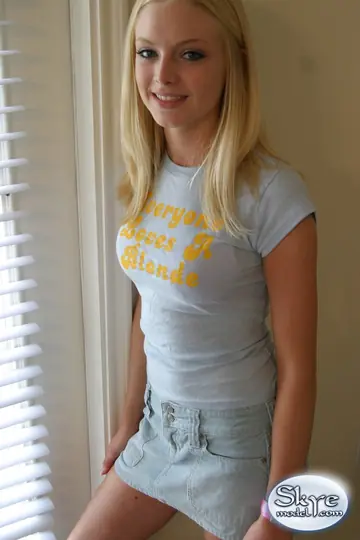 Blonde with Small Natural Tits and a Piercing Poses in a Skirt