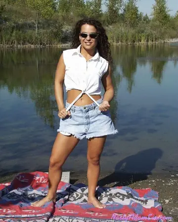 Woman in Shorts and Glasses Takes Two Men Outdoors