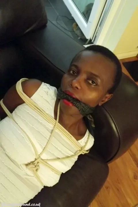 Ebony Brunette Spreads Her Legs While Bound and Cleave Gagged on Leather Sofa – photo 14 of 16