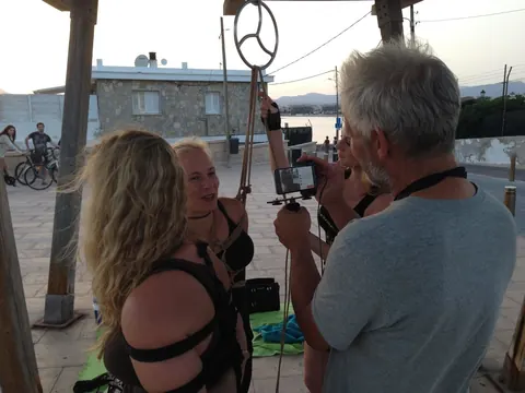 Blonde Hangs Suspended in Rope Bondage Outdoors Fully Clothed – photo 13 of 16